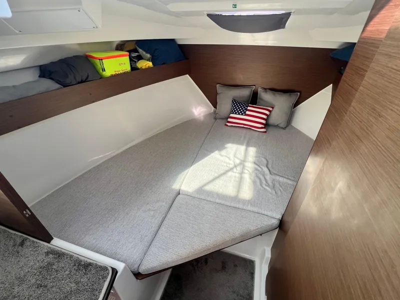 Slide: The Image of Cozy cabin interior of 2022 Jeanneau NC 795 S2 with cushions and American flag pillow. - 32