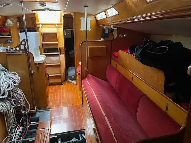 Slide: The Image of Interior of 1984 Farr 44 Custom sailboat with red seating and wooden cabinetry. - 10