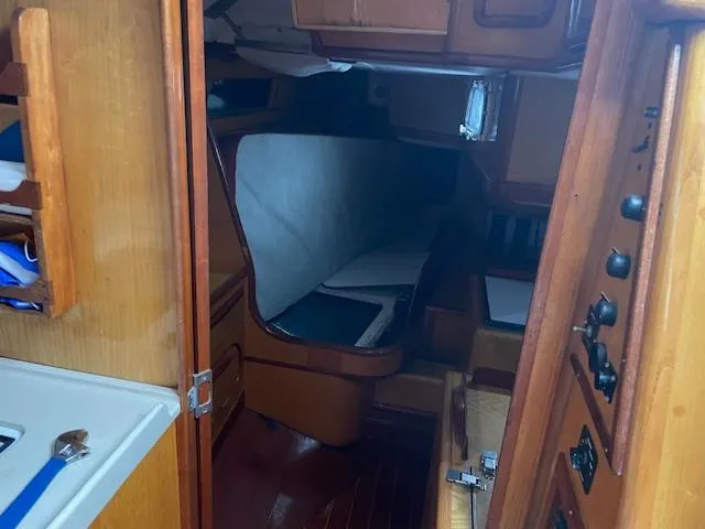 Slide: The Image of Interior of 1984 Farr 44 Custom sailboat, featuring wooden cabinetry and cozy sleeping area. - 11