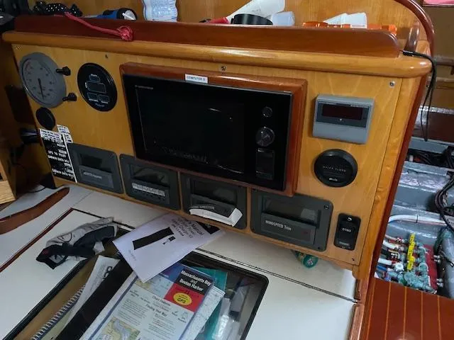 Slide: The Image of Control panel of a 1984 Farr 44 Custom yacht with navigation instruments and documents. - 12