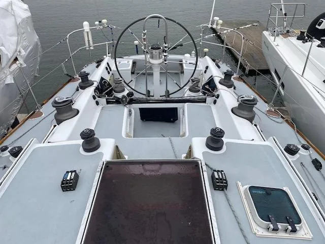 Slide: The Image of 1984 Farr 44 Custom sailboat deck with steering wheel and winches, docked at marina. - 18