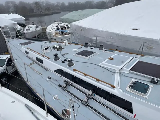 Slide: The Image of 1984 Farr 44 Custom sailboat docked, covered in winter storage, with other boats nearby. - 19