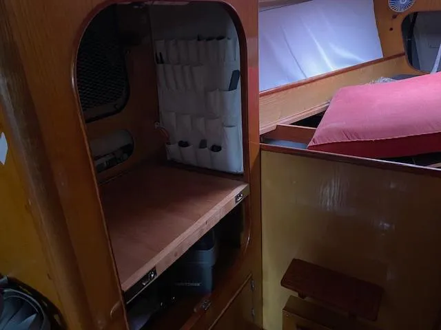 Slide: The Image of Interior of 1984 Farr 44 Custom sailboat with wooden cabinetry and storage space. - 9