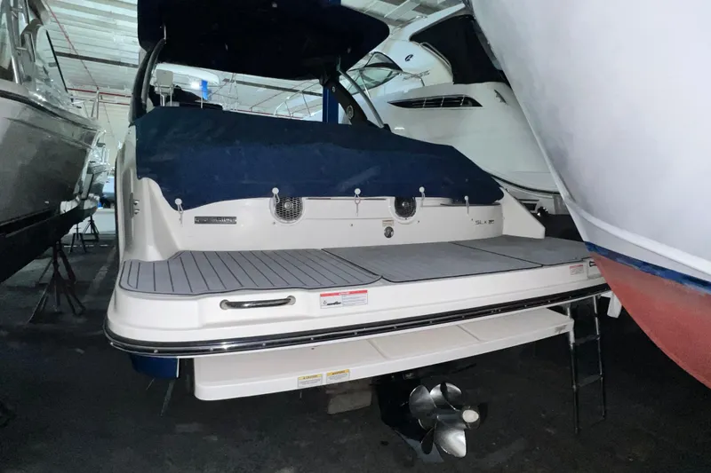 Slide: The Image of 2017 Sea Ray 280 SLX boat in storage, rear view with covered deck. - 10
