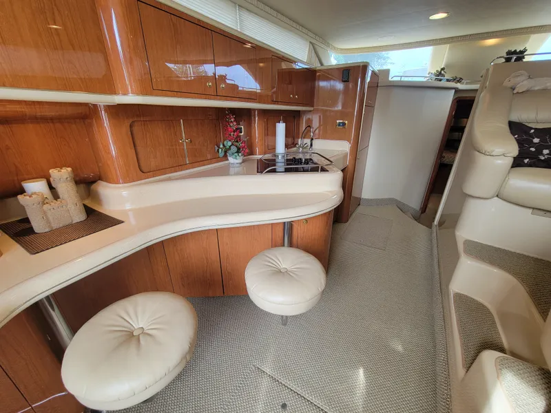 Slide: The Image of Luxurious interior of 2001 Sea Ray 450 Express Bridge yacht with modern kitchen and seating. - 13