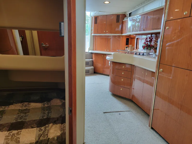 Slide: The Image of Interior of 2001 Sea Ray 450 Express Bridge with wood cabinetry and cozy sleeping area. - 24