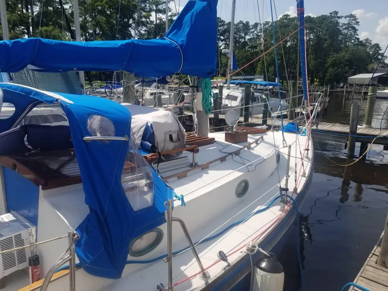 Slide: The Image of 1977 Ericson 31 sailboat docked with blue cover. - 1