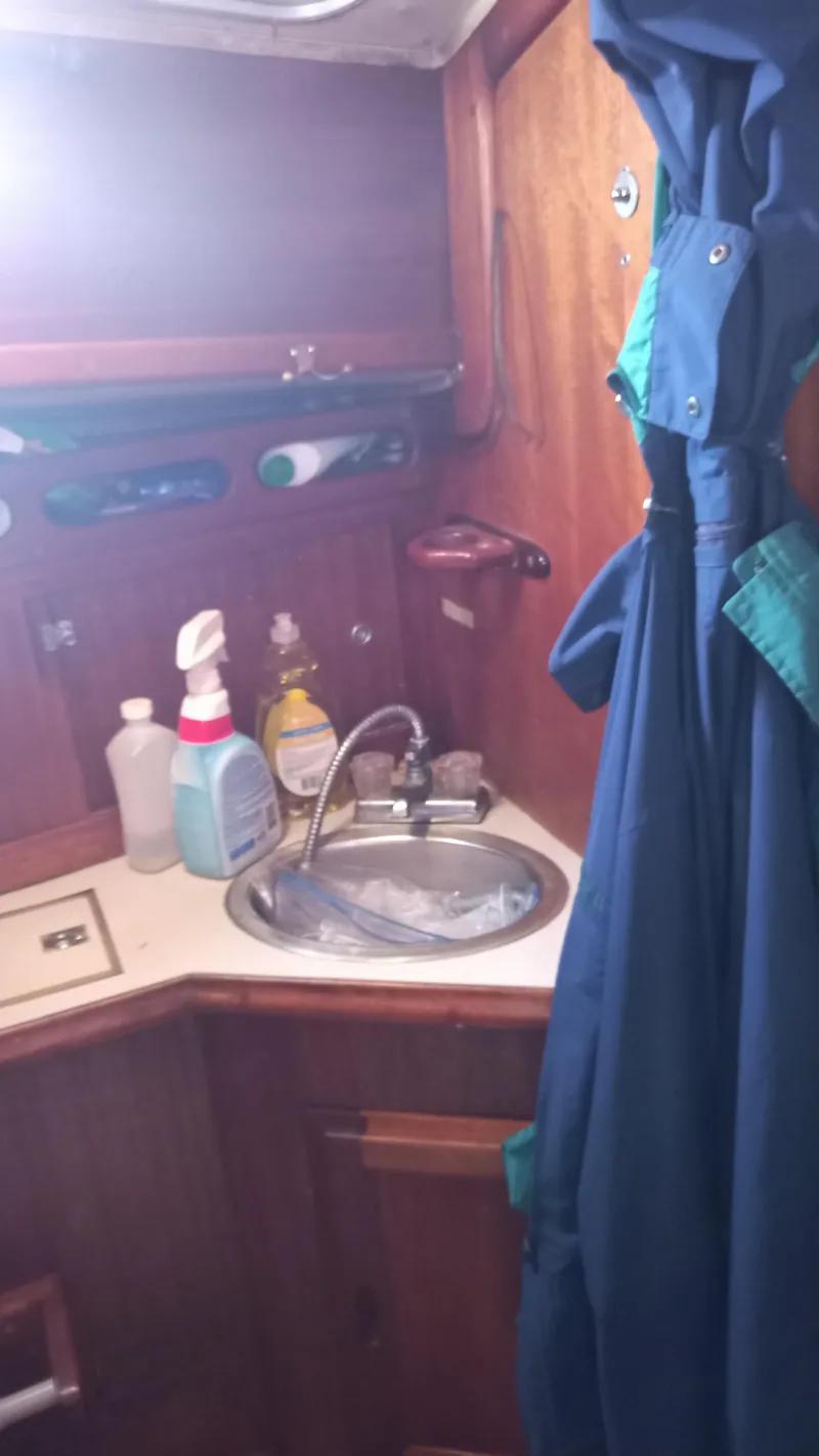 Slide: The Image of Interior of a 1977 Ericson 31 yacht with sink and cleaning supplies. - 13