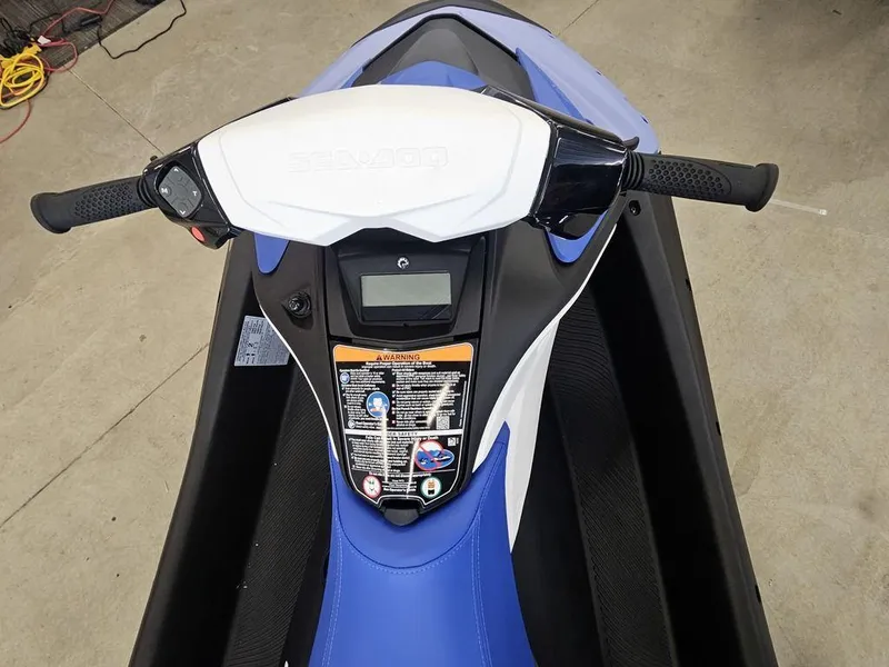 Slide: The Image of 2025 Sea-Doo Spark™ jet ski dashboard, featuring handlebars and control panel in a garage setting. - 4