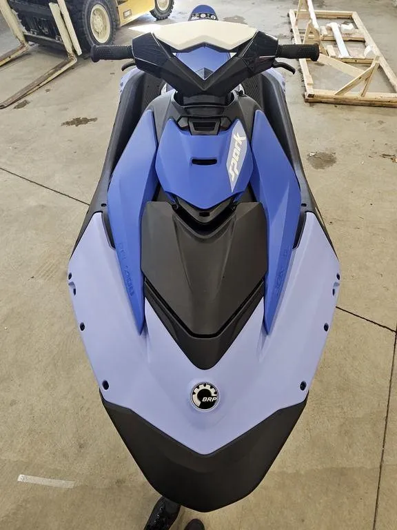 Slide: The Image of 2025 Sea-Doo Spark™ jet ski, blue and black, parked indoors. - 5