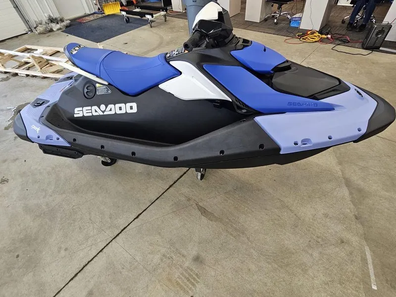Slide: The Image of 2025 Sea-Doo Spark™ jet ski, blue and black, in a garage setting. - 6
