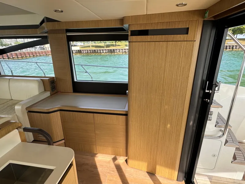 Slide: The Image of Interior of 2017 Absolute 50 Fly yacht with wooden cabinetry and large window view. - 16
