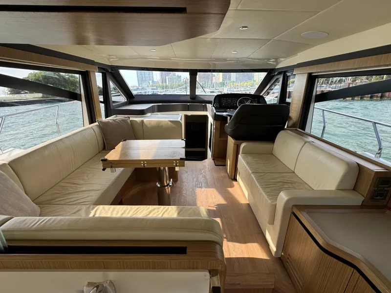 Slide: The Image of Luxurious interior of a 2017 Absolute 50 Fly yacht with beige seating and wooden accents. - 17