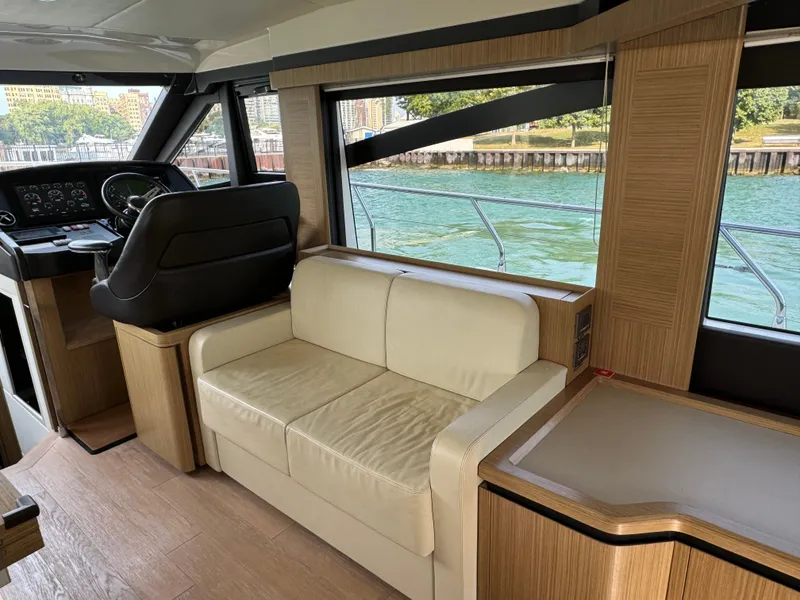 Slide: The Image of Interior of 2017 Absolute 50 Fly yacht with beige seating and helm, overlooking water. - 20