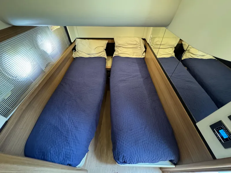Slide: The Image of Twin beds with blue covers in a 2017 Absolute 50 Fly yacht cabin. - 32