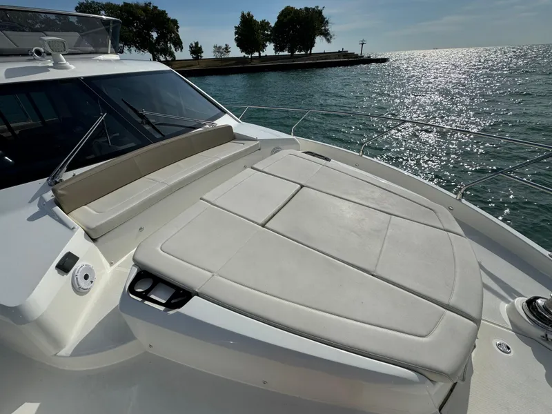 Slide: The Image of 2017 Absolute 50 Fly yacht with sunbathing area, overlooking serene water and distant trees. - 34