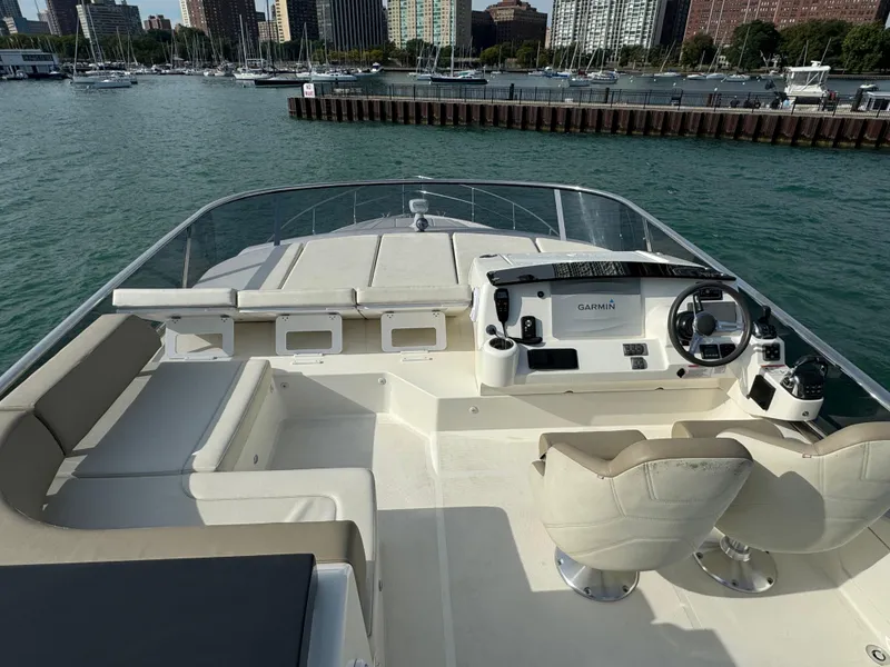 Slide: The Image of Flybridge of 2017 Absolute 50 Fly yacht with helm and seating, docked in a marina. - 8