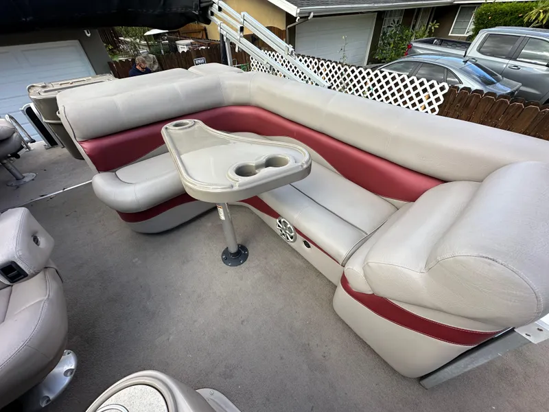 Slide: The Image of 2009 Premier 251 Castaway boat interior with beige and red seating, cup holders, and table. - 14