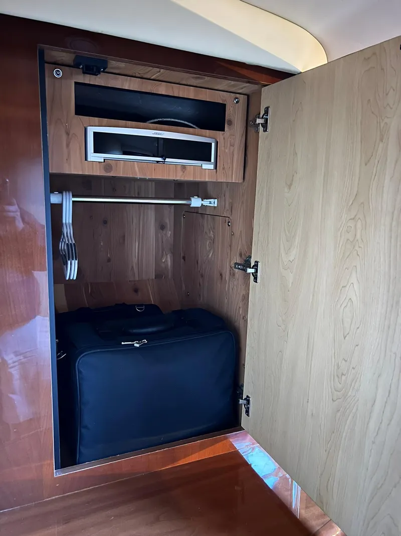 Slide: The Image of 2007 Sea Ray 52 Sundancer wooden cabinet with storage and suitcase. - 35