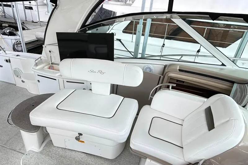 Slide: The Image of 2007 Sea Ray 52 Sundancer cockpit with white seating and modern amenities. - 82