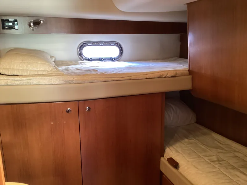 Slide: The Image of 2004 Tiara Yachts 4400 Sovran cabin with wooden interior and cozy bunk beds. - 11