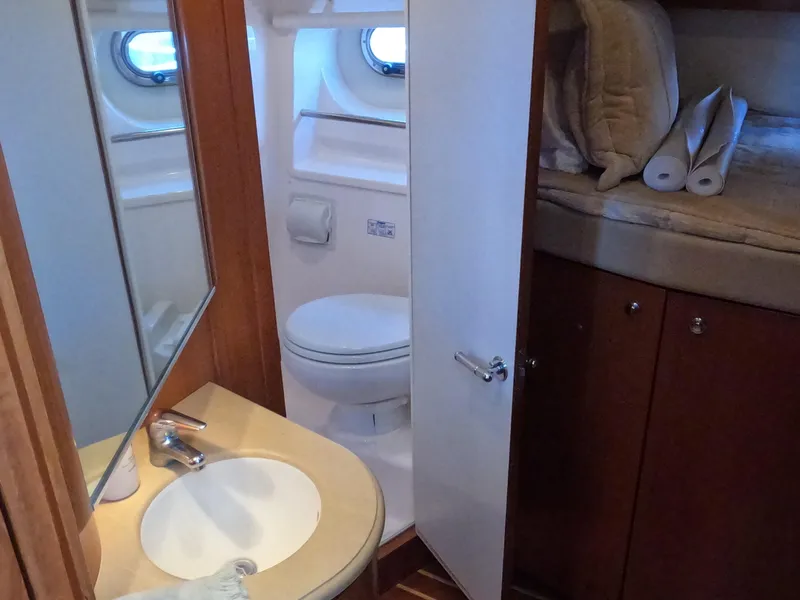 Slide: The Image of 2004 Tiara Yachts 4400 Sovran bathroom with sink, toilet, and storage. - 12
