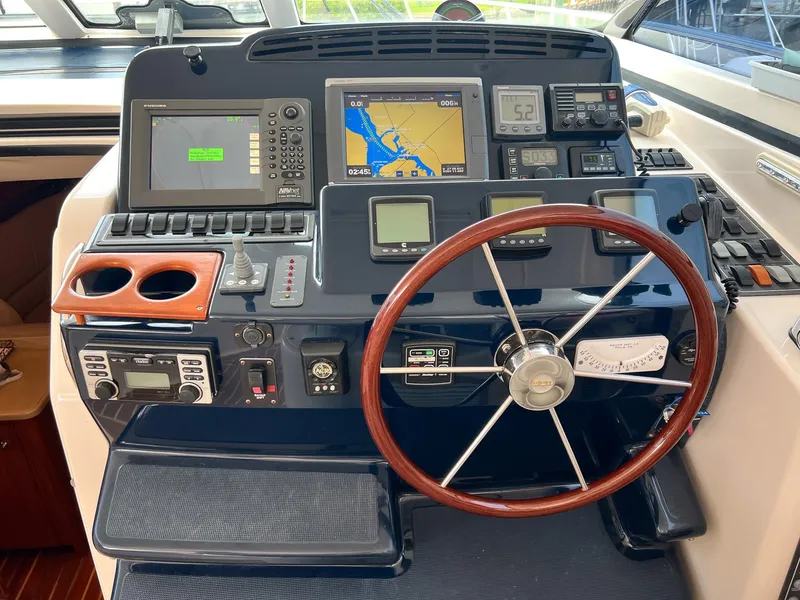 Slide: The Image of Helm of 2004 Tiara Yachts 4400 Sovran with navigation equipment and wooden steering wheel. - 23
