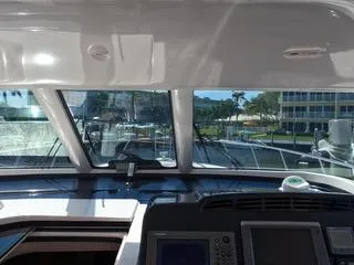 Slide: The Image of Interior view of 2004 Tiara Yachts 4400 Sovran helm with marina in background. - 24