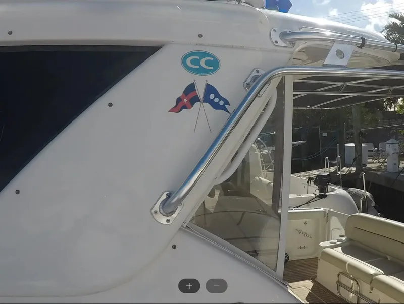 Slide: The Image of 2004 Tiara Yachts 4400 Sovran, side view with nautical flags and seating area. - 27