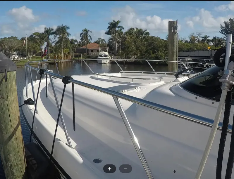 Slide: The Image of 2004 Tiara Yachts 4400 Sovran docked in a scenic marina setting. - 29