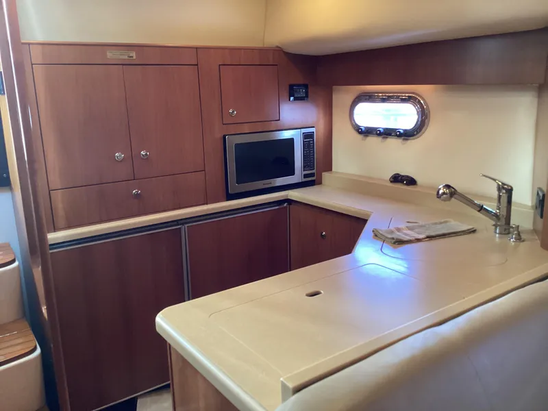 Slide: The Image of 2004 Tiara Yachts 4400 Sovran kitchen with wood cabinetry and modern appliances. - 3