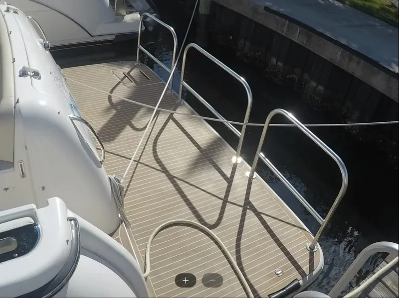 Slide: The Image of 2004 Tiara Yachts 4400 Sovran deck with railing, docked by the water. - 37