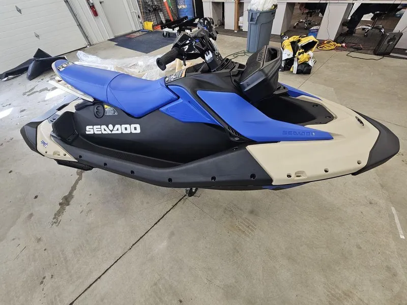 Slide: The Image of 2025 Sea-Doo Spark Trixx jet ski in blue and black, parked indoors. - 3