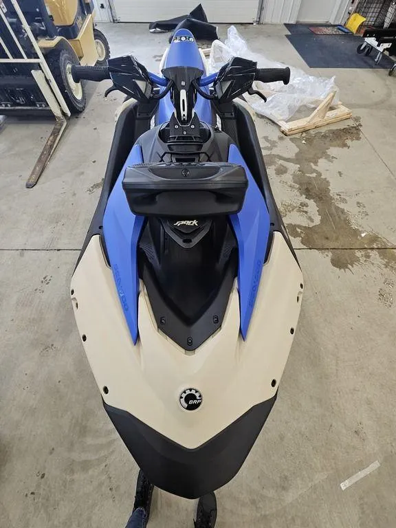 Slide: The Image of 2025 Sea-Doo Spark Trixx jet ski, blue and white, in a garage setting. - 5