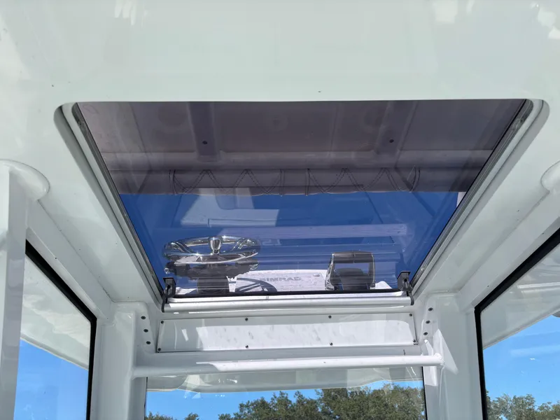 Slide: The Image of 2022 Costa Custom Boats 264HC helm with blue-tinted windshield and steering wheel. - 28