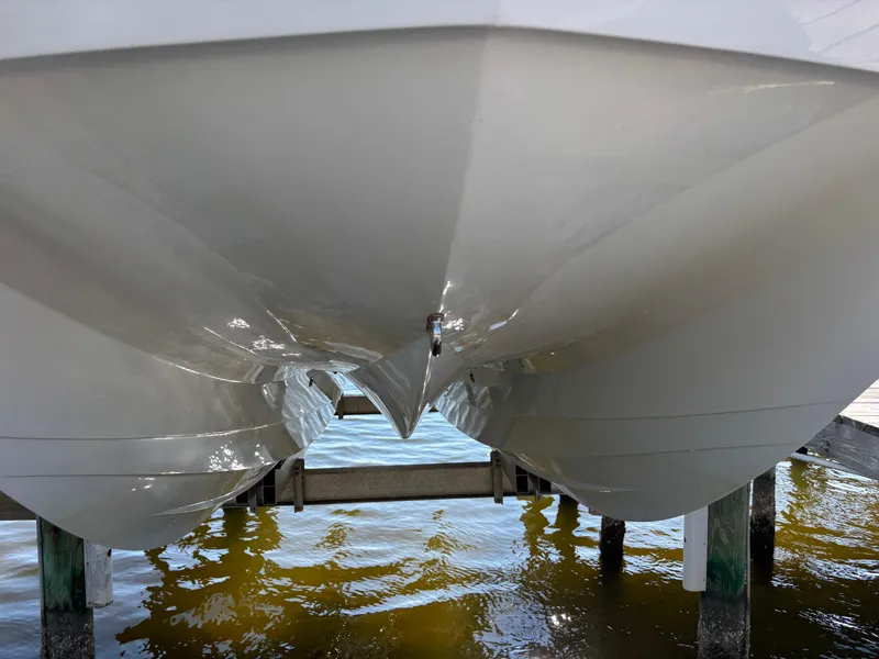 Slide: The Image of 2022 Costa Custom Boats 264HC catamaran hull on lift over water. - 3