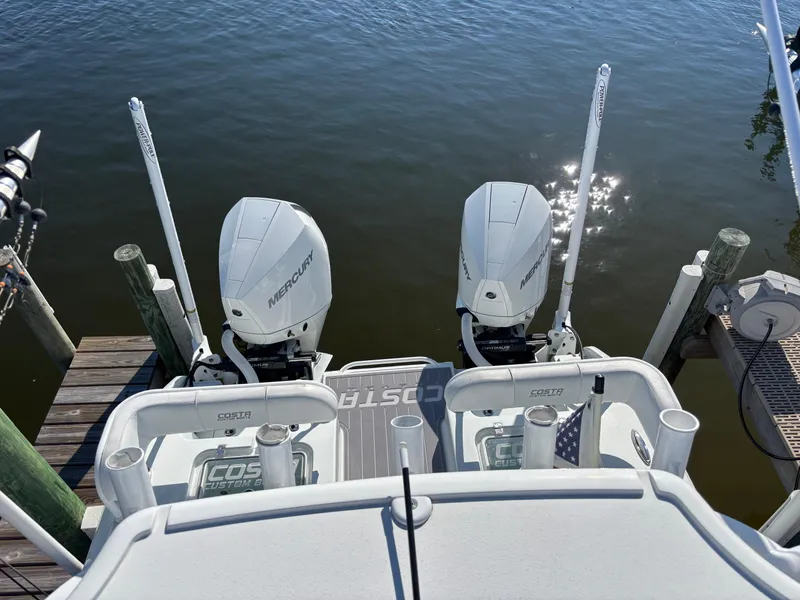Slide: The Image of 2022 Costa Custom Boats 264HC with twin Mercury engines docked on calm water. - 33