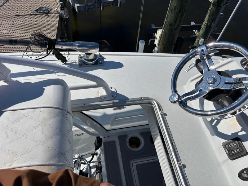 Slide: The Image of 2022 Costa Custom Boats 264HC helm with steering wheel and seating, docked at marina. - 37