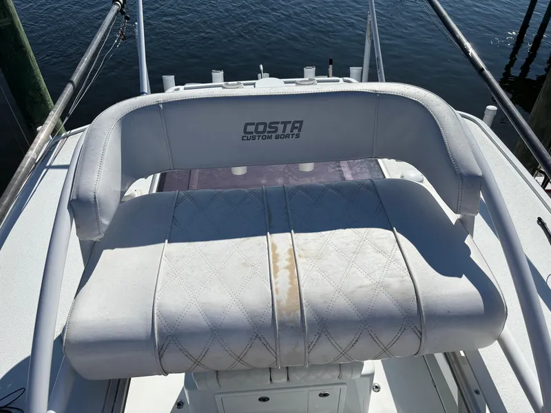 Slide: The Image of Costa Custom Boats 264HC 2022 model, featuring a cushioned seating area on deck. - 39