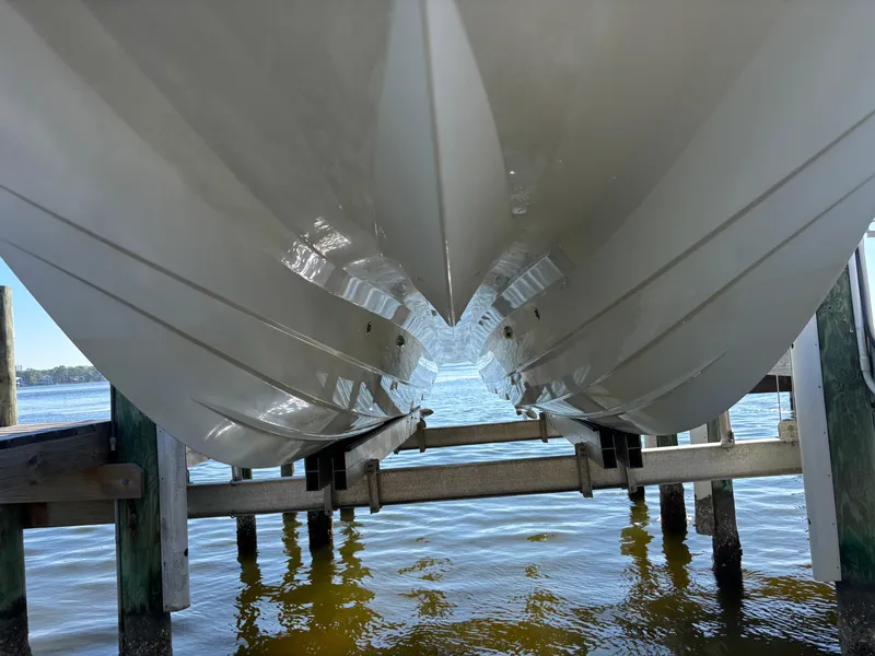 Slide: The Image of Close-up of 2022 Costa Custom Boats 264HC hull on a lift over water. - 4