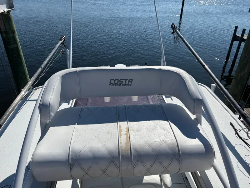 Slide: The Image of Costa Custom Boats 264HC 2022 model, white seating, docked by the water. - 40