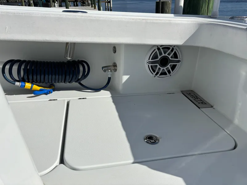 Slide: The Image of Costa Custom Boats 264HC 2022 model, featuring deck storage and coiled hose. - 45