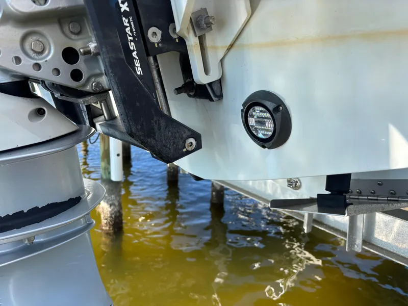 Slide: The Image of Close-up of 2022 Costa Custom Boats 264HC motor and hull near water. - 5