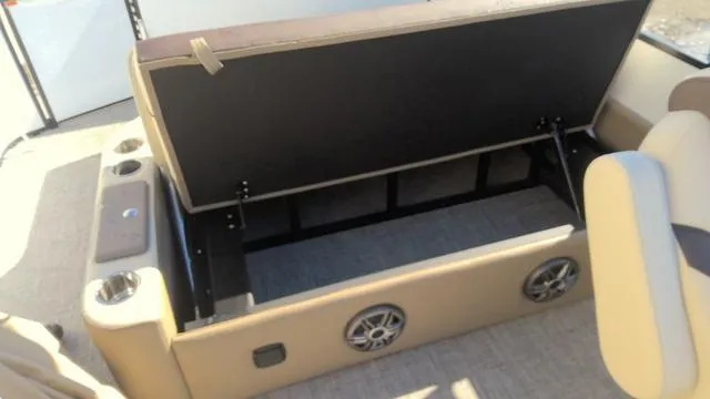 Slide: The Image of Open storage compartment in 2025 SunCatcher Select 324SL boat with cup holders and speakers. - 14