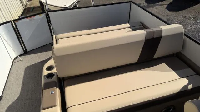 Slide: The Image of SunCatcher Select 324SL 2025 boat interior with beige seating and cup holders. - 16