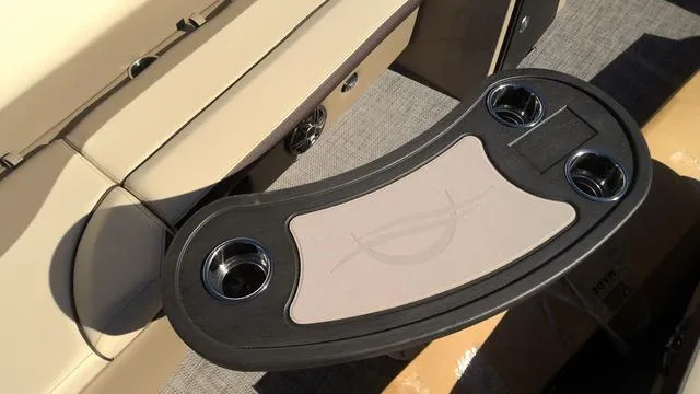 Slide: The Image of SunCatcher Select 324SL 2025 boat interior with cup holders and beige seating. - 6