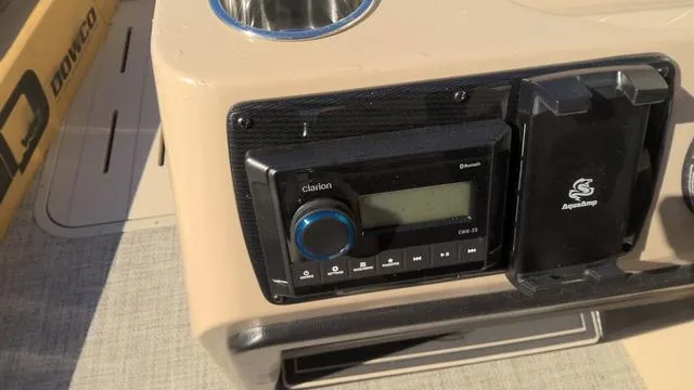Slide: The Image of SunCatcher Select 324SL 2025 boat console with Clarion audio system and cup holder. - 9