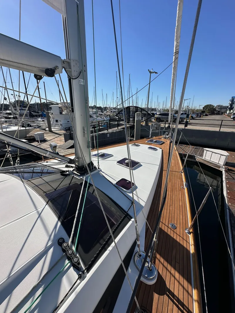 Slide: The Image of 2013 Jeanneau 57 sailboat docked at marina, showcasing deck and rigging. - 14