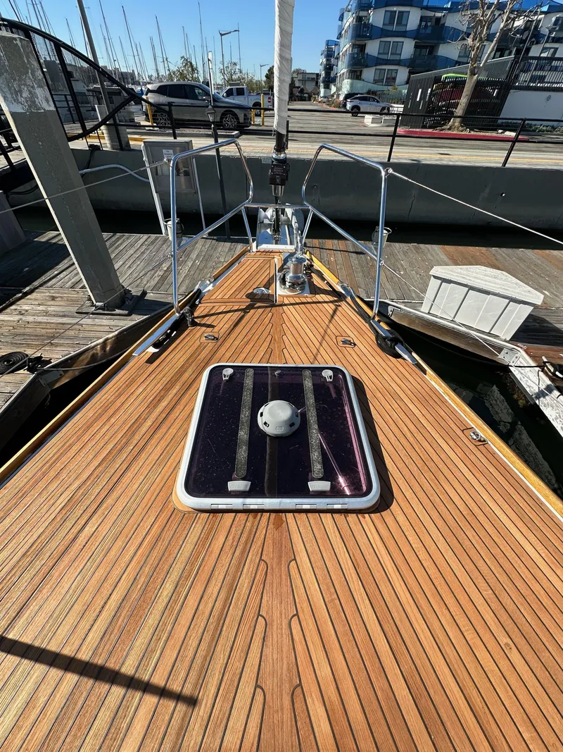Slide: The Image of 2013 Jeanneau 57 sailboat deck with wooden finish at marina. - 16