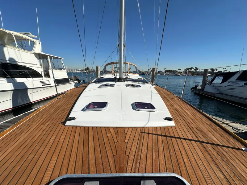 Slide: The Image of 2013 Jeanneau 57 sailboat with teak deck, docked in a marina. - 23